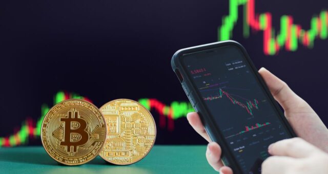 Celular ao lado de bitcoin (BTC)