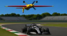 Avião voa de cabeça para baixo sobre carro de Fórmula 1.