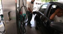 Frentista abastece carro em posto de combustível no Rio de Janeiro.
