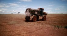 Trator espalha fertilizante em um campo de soja, nas proximidades de Brasília,