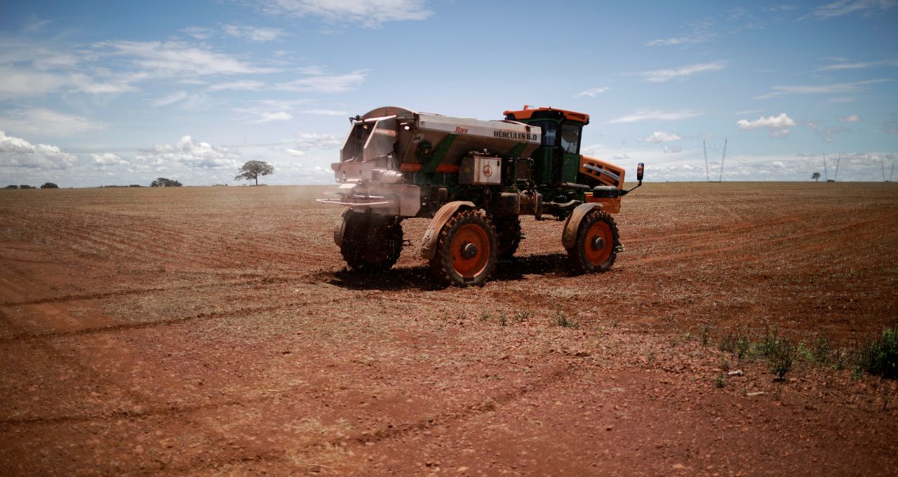 Trator espalha fertilizante em um campo de soja, nas proximidades de Brasília,