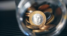 Real, Money from Brazil. Brazilian coins inside a glass jar. Highlight for 1 Real coin. Brazilian economy. Dark environment. Macro photography.